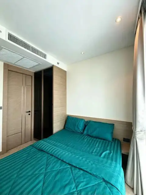 1 Bedroom Condo for Rent at Riviera Ocean Drive bedroom with teal bed linens and built-in wood wardrobe