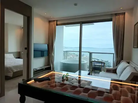 1 Bedroom Condo for Rent at Riviera Ocean Drive living area with glass coffee table and bedroom view