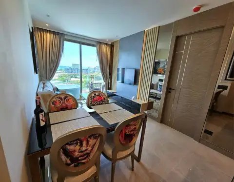 1 Bedroom Condo for Rent at Riviera Ocean Drive dining table with pop-art chairs and city view through balcony window