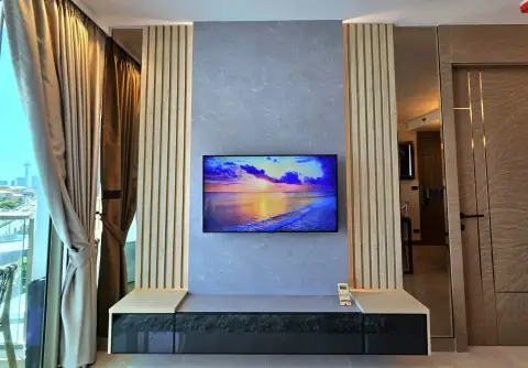 1 Bedroom Condo for Rent at Riviera Ocean Drive living area feature wall with mounted TV and wood slat accents