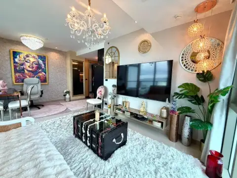 2 Bedroom Condo for Sale at Riviera Ocean Drive lounge area with flat-screen TV, plush rug and colorful wall art