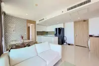 2 Bedroom Condo for Rent at Riviera Wong Amat Beach open-plan kitchen with white cabinets, black refrigerator, and dining area