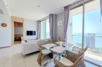 2 Bedroom Condo for Rent at Riviera Wong Amat Beach dining area with glass table, rattan chairs, and balcony overlooking the ocean