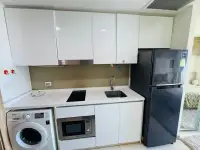 1 Bedroom Condo for Sale at Riviera Wong Amat Beach compact kitchen with white cabinets and fridge