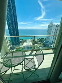 1 Bedroom Condo for Sale at Riviera Wong Amat Beach balcony with sea view and green bistro chairs