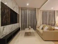 1 Bedroom Condo for Rent at Riviera Wong Amat Beach open living area with marble feature wall and sheer curtains