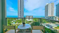 1 Bedroom Condo for Rent at Riviera Wong Amat Beach balcony with seating and sea view amid high-rise towers