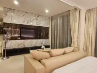 1 Bedroom Condo for Rent at Riviera Wong Amat Beach living room with marble TV wall and beige sofa bed
