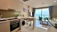 2 Bedroom Condo for Sale at Riviera Wong Amat Beach open kitchen and living area with sea view through balcony
