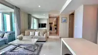 2 Bedroom Condo for Sale at Riviera Wong Amat Beach bright living room with sofa, mirrored wall and balcony access