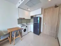 1 Bedroom Condo for Sale at Riviera Wong Amat Beach compact kitchen with fridge, washing machine, and cabinets