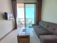1 Bedroom Condo for Sale at Riviera Wong Amat Beach sofa and wall-mounted TV with balcony sea view