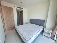 1 Bedroom Condo for Sale at Riviera Wong Amat Beach bedroom with king bed and en-suite bathroom entrance