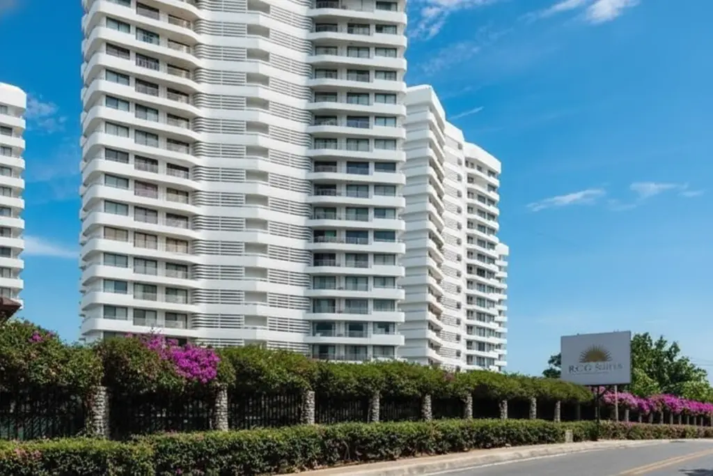 Royal Cliff Garden exterior of white high-rise condo building from street level with green hedges and sign.