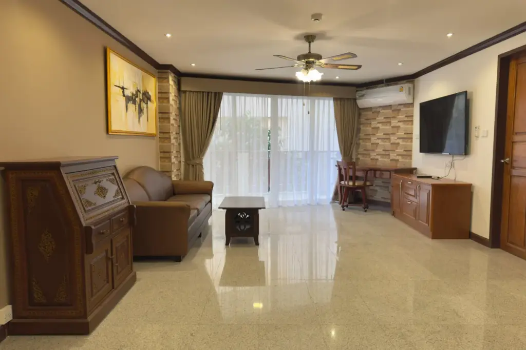 2 Bedroom Condo for Rent at Royal Hill Resort living room with leather sofa, wall-mounted TV and balcony access