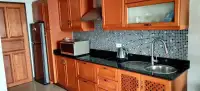 1 Bedroom Condo for Sale at Royal Hill Resort kitchen with wooden cabinetry, black granite counters, and mosaic backsplash