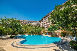 Royal Hill Resort large outdoor swimming pool with lounge chairs and lush tropical landscaping under a blue sky.