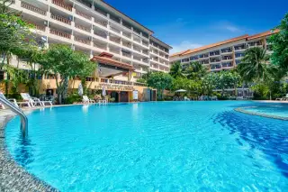 Royal Hill Resort inviting outdoor swimming pool with resort buildings, palm trees, and clear blue water.