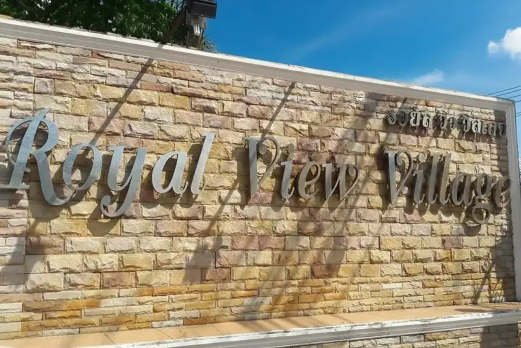 Royal View Village entrance sign made of stone with metal lettering.