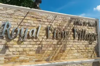 Royal View Village entrance sign made of stone with metal lettering.