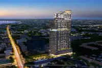 1 Bedroom Condo for Sale at Once Wong Amat illuminated high-rise tower exterior at dusk with city and coastline views