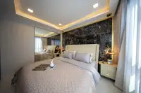 1 Bedroom Condo for Sale at Grand Solaire Noble bedroom with mirrored wardrobe, black marble accent wall and gold ceiling trim