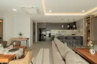 3 Bedroom Condo for Sale at Zensiri Estates and Residences open-plan layout showing dining table, sofa, and fully equipped kitchen with island