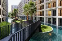 Studio Condo for Sale at The Indeed Condo Pattaya lagoon-style pool with tropical palm trees and landscaped courtyard