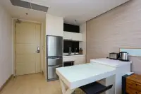 1 Bedroom Condo for Sale at Cetus Beachfront compact kitchen with stainless steel fridge, white cabinets, and breakfast bar with bar stools