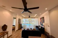 4 Bedroom Condo for Sale at Cetus Beachfront living room with large ceiling fan, blue sofas and beachfront pool view