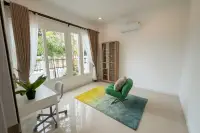 3 Bedroom House for Sale at The Flow Pong - Mabprachan rear exterior with covered patio, tiled terrace and lush green garden at dusk