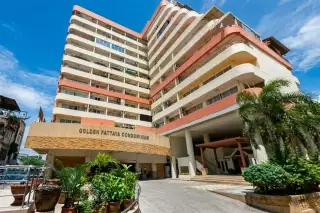 Golden Pattaya Condominium multi-story building exterior with main entrance, palm trees, and clear blue sky.