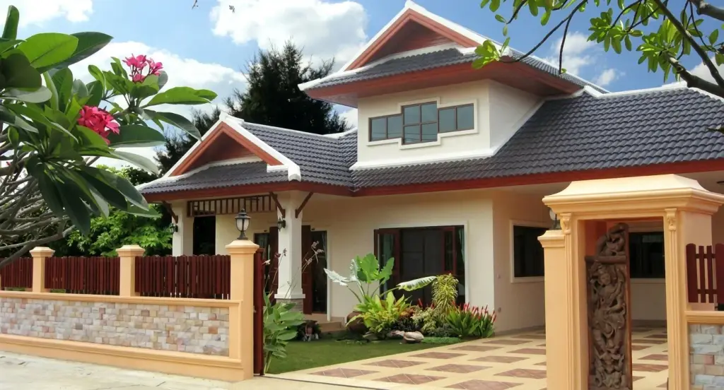 Rose Land & House: Exterior of a modern single-story house with a dark tiled roof, cream walls, covered carport, and a stone fence.