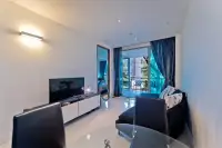 2 Bedroom Condo for Sale at The Sanctuary Wongamat living room with blue sofa and balcony view of trees