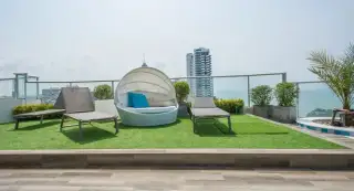 Sands Condominium aerial view of the tall white building overlooking the blue ocean and coastline in Pattaya.