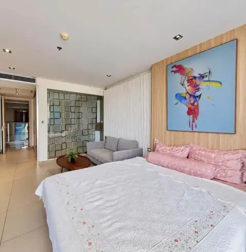 1 Bedroom Condo for Rent at Sands Condominium living area with gray loveseat, round coffee table, and slatted wood wall