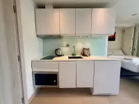 Studio Condo for Sale at Sands Condominium compact kitchenette with white cabinets, sink and microwave