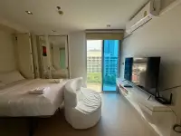 Studio Condo for Sale at Sands Condominium bedroom with white bedding, TV, mirrored closet and balcony access