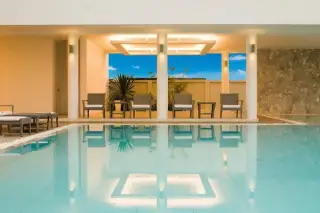Sea Breeze Villa Pattaya covered poolside lounge area with illuminated ceiling and reflections in the water.