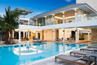 Sea Breeze Villa Pattaya expansive outdoor swimming pool area with modern villa, lounge chairs, and ocean view.