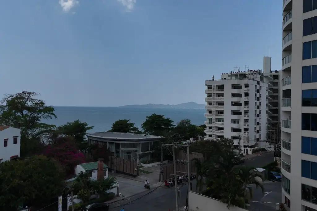 1 Bedroom Condo for Sale at Sea Sky By Sand elevated sea view overlooking Pattaya coastline and nearby high-rise buildings