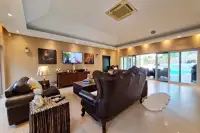 4 Bedroom House for Sale & Rent at Sedona Villas 1 living room with leather sofas, TV, and pool view through sliding doors