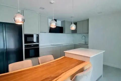 2 Bedroom Condo for Rent at Serenity Residence Jomtien modern kitchen with pendant lights and wood dining table