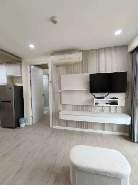 1 Bedroom Condo for Sale at Seven Seas Condo Resort living area with wall-mounted TV, kitchen and air conditioning
