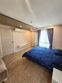 1 Bedroom Condo for Sale at Seven Seas Condo Resort bedroom with blue bedding, mirrored closet, and curtains