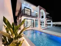 4 Bedroom House for Sale in Mabprachan two-story villa exterior with illuminated pool at night