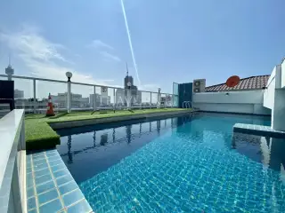Siam Oriental Elegance 2 rooftop swimming pool with city skyline view and outdoor seating.