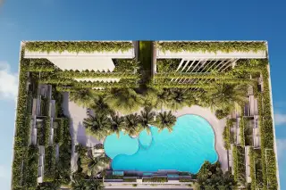Siam Oriental Oasis large, irregularly shaped swimming pool with sun loungers, surrounded by tropical plants and a building facade.