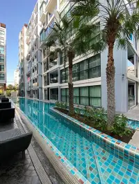 1 Bedroom Condo for Sale at Siam Oriental Tropical Garden outdoor swimming pool lined with palm trees