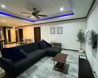 2 Bedroom Condo for Rent at Siam Oriental Twins living room with dark sectional sofa and blue LED ceiling accent